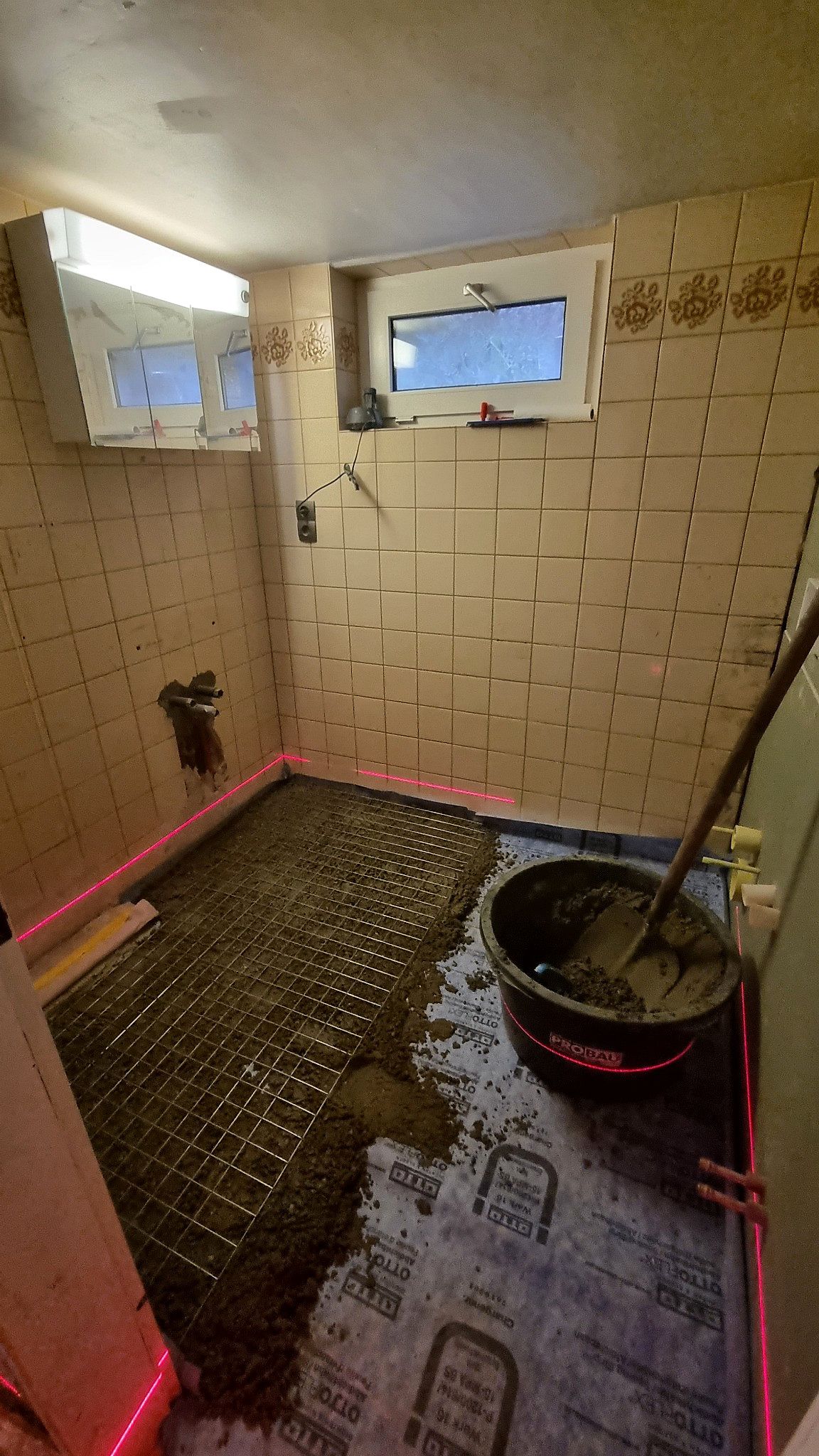 Badezimmer im Rückbau: alte Fliesen entfernt, Bodenaufbau freigelegt